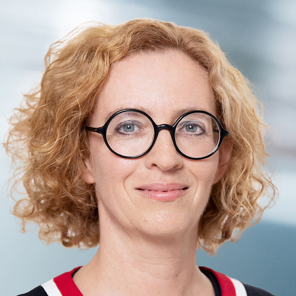 Portrait of Prof. Dr. Claudia Witt, female, fair-skinned, wearing a sweater, glasses, and medium-length blonde hair.
